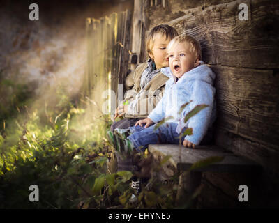 Two brothers sitting on a wall having fun Stock Photo