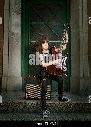 Girl dressed as a rock star playing the guitar Stock Photo