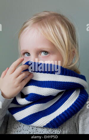 Portrait of a girl hiding behind her scarf Stock Photo