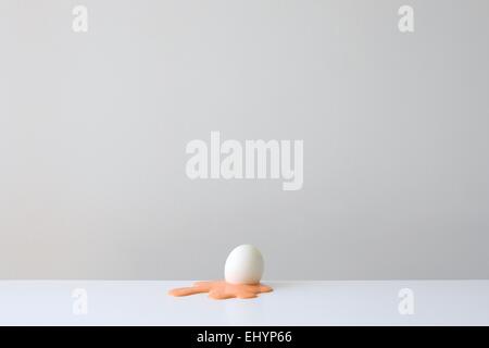 Conceptual egg shell on yellow yolk Stock Photo