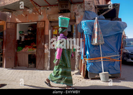 Woman in traditional African dress carrying basket on her head, Medina, old town, Marrakesh, Marrakech, Morocco, North Africa Stock Photo