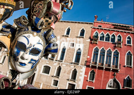 Venetian Carneval masks in front of buildings. Stock Photo