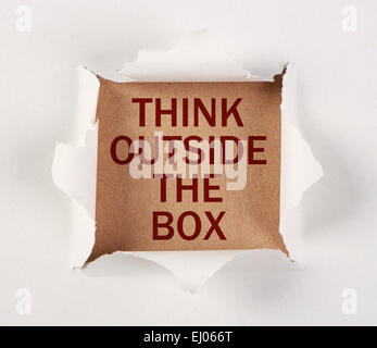 Think outside the box with tear paper on brown. Stock Photo
