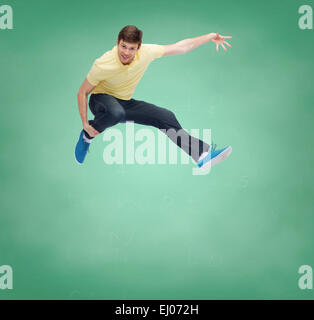 smiling young man jumping in air Stock Photo