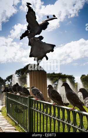 Argentina, Buenos Aires, Cabalito, Parque Centenario, Centenary Park, pigeons in railings around Angel statue overlooking lake Stock Photo