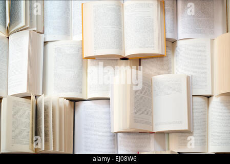 Many open books piled up. unreadable text Stock Photo
