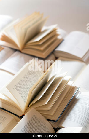 Many open books piled up. unreadable text. Copy space Stock Photo