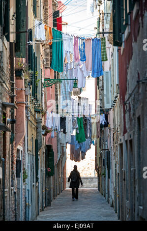 Laundry on clothesline in a narrow street in Castello district. Stock Photo