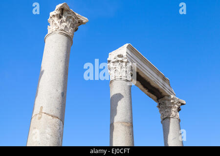 Ancient columns and portico fragment on blue sky background, fragment of ruined roman temple in Smyrna. Izmir, Turkey Stock Photo