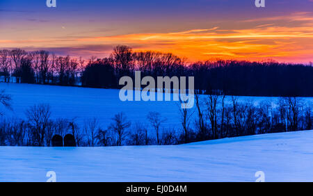 Sunset over snow-covered rolling hills in rural York County, Pennsylvania. Stock Photo