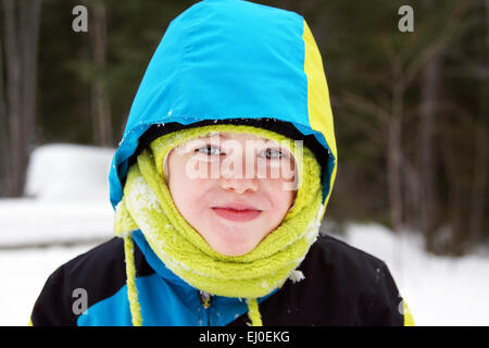 Cute boy playing outside in the woods on cold winter day Stock Photo