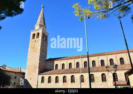 The ancient roman basilica of Saint Euphemia in Grado Italy. The clock tower is surmounted by the archangel Michael Stock Photo