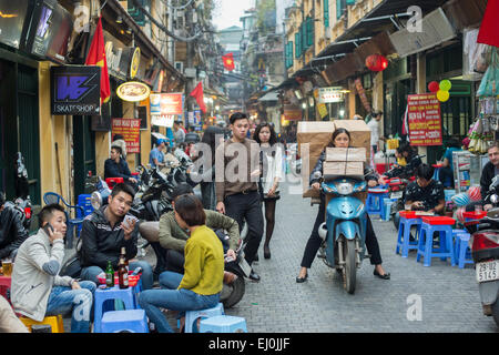 Vietnamese woman transports a huge load on a motorbike in the old quarter of Hanoi. Stock Photo