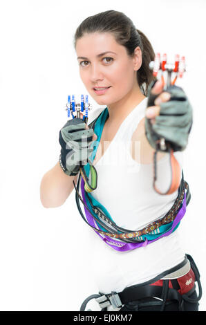Young woman equipped with climbing gear holding camming device Stock Photo