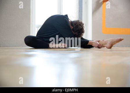 Man doing exercise on the legs at gym Stock Photo