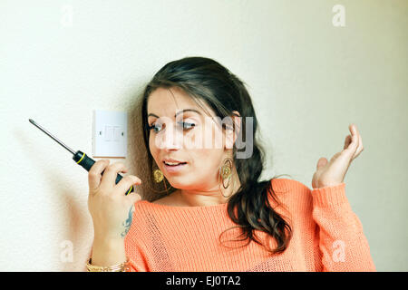 Woman confused by electrical DIY in the home Stock Photo