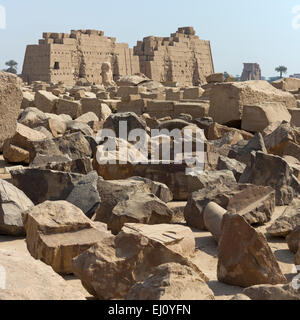 View over magazines of broken blocks to the colossal statues in front of the Eighth Pylon at the Temple  at Karnak, Luxor Egypt Stock Photo