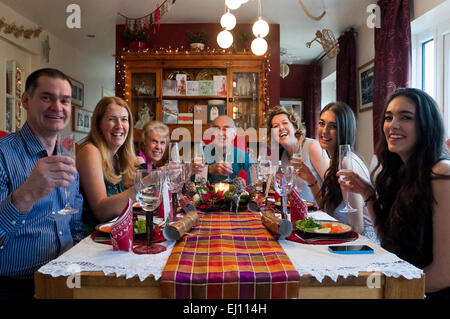 Horizontal view of three generations of a family enjoying Christmas lunch together. Stock Photo