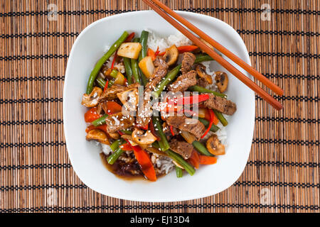 Asian styled beef, green bean, red pepper, mushroom and carrots stir fried with oyster sauce, served with white rice Stock Photo