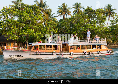 People cruising on a boat on the Vembanad Lake in Kumarakom, Kerala India Stock Photo