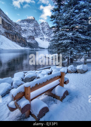 Bench with First snow of the season on Moraine Lake. Banff National Park, Alberta, Canada Stock Photo