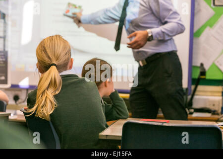 Primary school girls are taught during a lesson by a male teacher Stock Photo