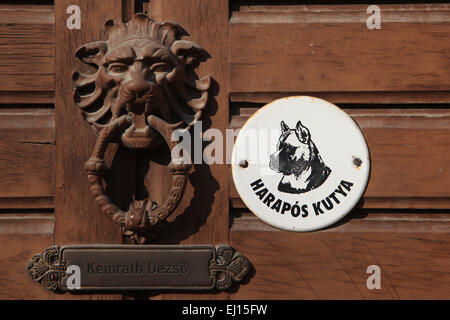 Harapos Kutya! Beware of the Dog! Warning sign and knocker at the door in Mohacs, Hungary. Stock Photo