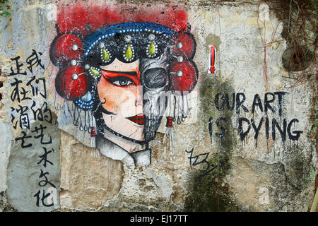 Anonymous street art in Georgetown Penang. Strange protest mural with the message that art is dying. Half Skull and Half Face. Stock Photo