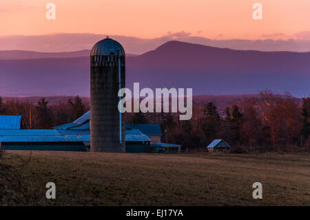 Barn and silo on a farm in the Shenandoah Valley at sunset, with Massanutten Mountain behind, near Luray, Virginia Stock Photo