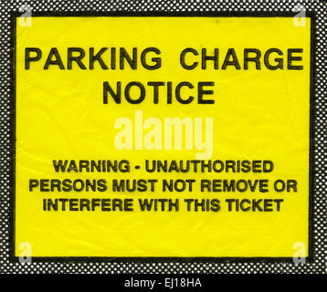 Parking charge notice in the UK showing the message Warning - unauthorised persons must not remove or interfere with this ticket Stock Photo
