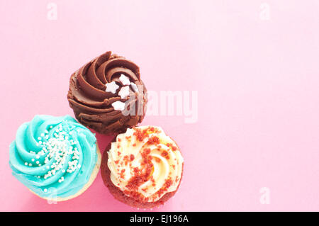Cupcakes over a pink backdrop with space for text Stock Photo