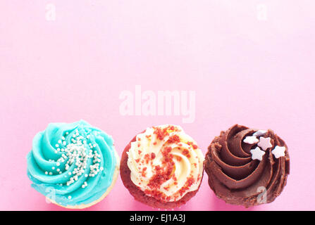 Cupcakes over a pink backdrop with space for text Stock Photo