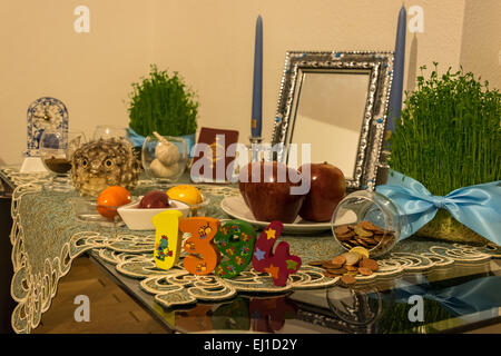 Nowruz, the Iranian New Year, will start at March 20, 2015 on 11:45PM. The photo shows a traditional 'Haft-seen' table. Haft-seen or the seven 'seen' traditional table includes seven items all start with the letter 's' (or called 'seen' in Farsi)  in the persian alphabet.  In the picture, lential sprouts, or Sabzeh in Farsi, is a symbol of rebirth. 'Senjed',dried oleaster Wild Olive fruit, is a symbol of love. 'Sir', garlic, symbolizes medicine. 'Sib', apple, is a symbol for health. 'Somaq', sumac fruit, is a symbol for (the color of ) sunrise. Serkeh, vinegar, symbolizing old-age and patience Stock Photo