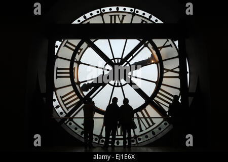Visitors look out thought the glass clock in the Musee d'Orsay in Paris, France. Stock Photo
