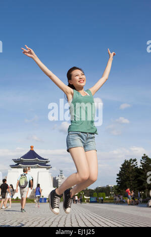 Young woman jumping in mid-air with smile, Stock Photo