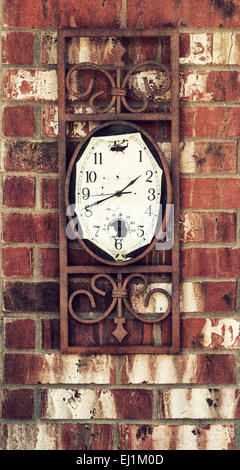 Old weathered clock hanging on brick wall Stock Photo