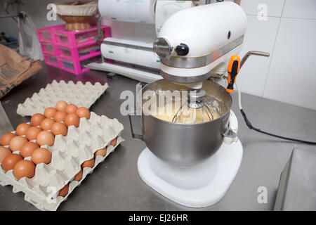 Churning mass in confectionery machine. Manufacturing process of spanish madeleines