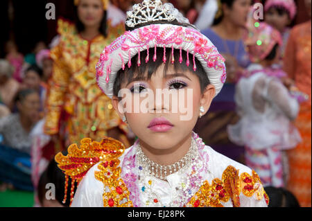 A young Burmese boy dressed in colourful robes and doll like make up for his coming of age ceremony in Mandalay Myanmar Stock Photo