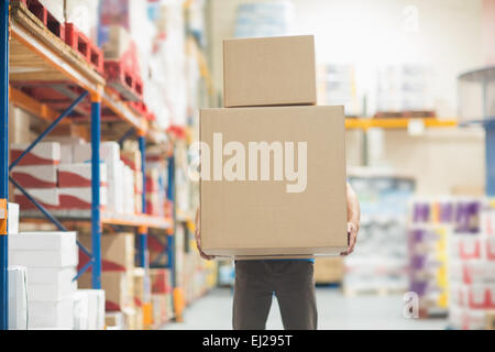 Worker carrying boxes in warehouse Stock Photo