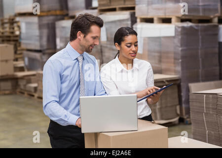 Warehouse managers working on laptop Stock Photo