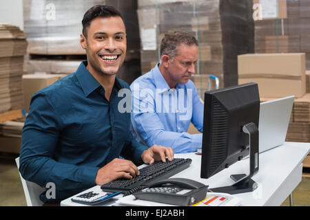 Two managers working on laptop at desk Stock Photo