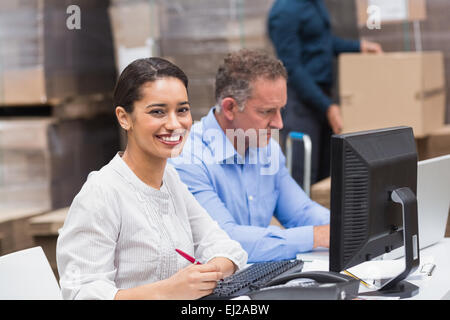 Two managers working on laptop at desk Stock Photo