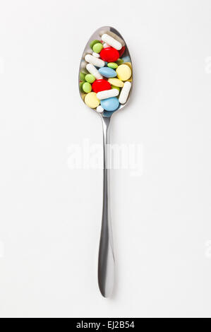 Many colorful pills and tablets in spoon. Stock Photo