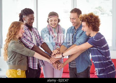 Students putting hands together Stock Photo - Alamy