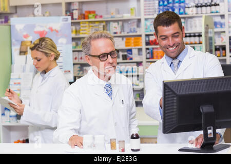 Team of pharmacists looking at computer Stock Photo