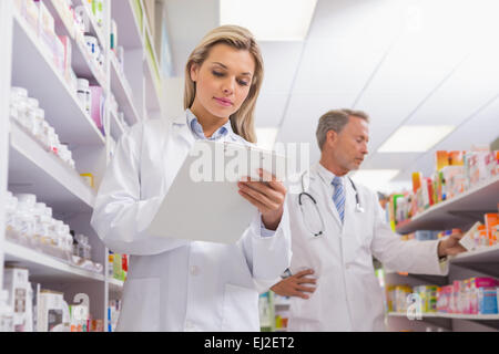 Young trainee writing on a prescription pad Stock Photo