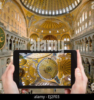 travel concept - tourist takes picture of interior and cupola on Hagia Sophia, Istanbul, Turkey on smartphone, Stock Photo