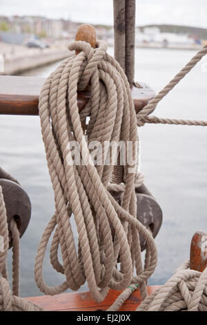 Ropes on belaying pins on board a tall ship Stock Photo