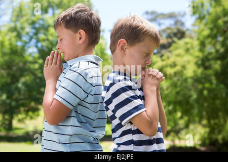 Little boys praying in the park Stock Photo