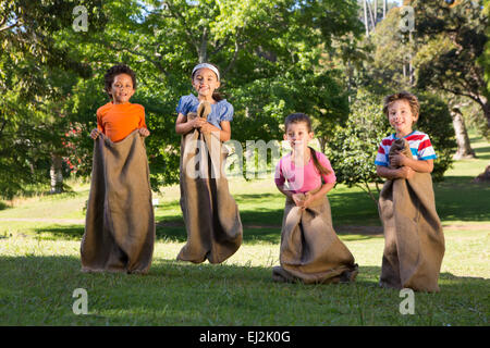 Children having a sack race in park Stock Photo